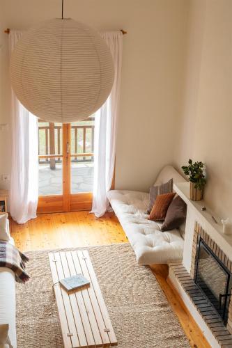 a living room with a couch and a large window at VYTINA LOFTS - Cozy 2-Level Loft Apartments with Fireplace & Mountain Views in Vitina