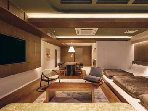 a room with a bed and a tv and a table at illi Eme Tokyo-Toranomon in Tokyo