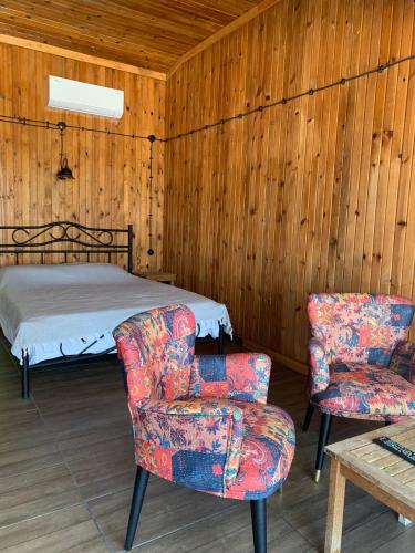 a bedroom with a bed and two chairs at Casamora in Edremit