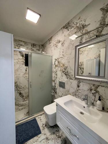 a bathroom with a sink and a toilet and a mirror at Master Vi in Dalaman