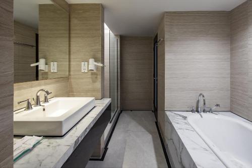 a bathroom with two sinks and a mirror at Hotel Santika Mataram in Mataram