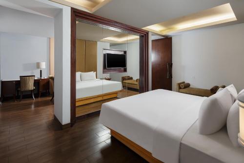 a hotel room with a bed and a mirror at Hotel Santika Mataram in Mataram