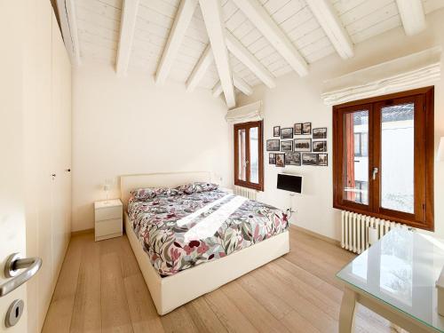 a white bedroom with a bed and a table at Venice Entry Comfort Apartment in Mestre