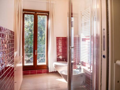 a bathroom with a toilet and a sink and a window at Venice Entry Comfort Apartment in Mestre