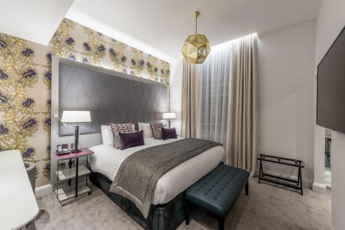 a hotel room with a bed and a large window at Mercure London Hyde Park Hotel in London