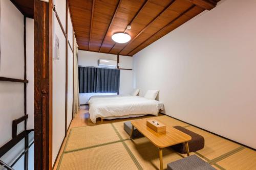 a bedroom with a bed and a table in it at YAGARA TERRACE HOUSE OSAKA Room B in Osaka