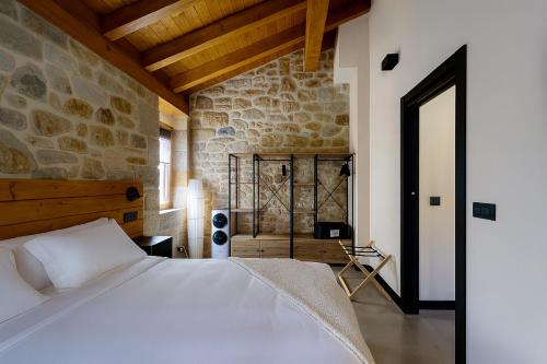 a bedroom with a bed and a stone wall at Solatsu Baserria - Apartamentos Rurales in Elorrio