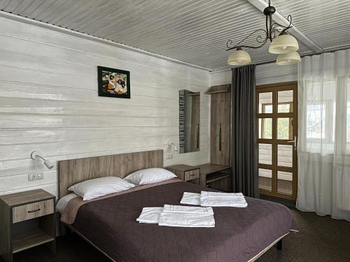 a bedroom with a bed with towels on it at Екосадиба Водограй in Kvasy