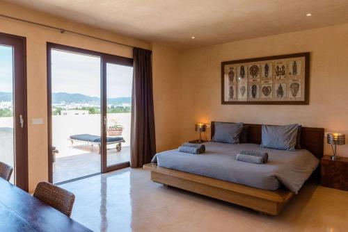 a bedroom with a bed with a view of a patio at Villa Sirio in Cala de Bou