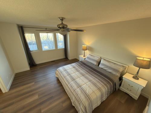 a bedroom with a bed and a ceiling fan at Spacious & Private Retreat near West Edmonton Mall in Edmonton