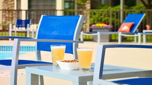 two glasses of beer sitting on a table with a bowl of peanuts at Staybridge Suites Boston - Burlington by IHG in Burlington