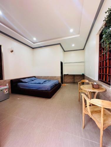 a bedroom with a bed and a table and chairs at An's House - Đóng trên booking - LH trực tiếp in Phan Thiet