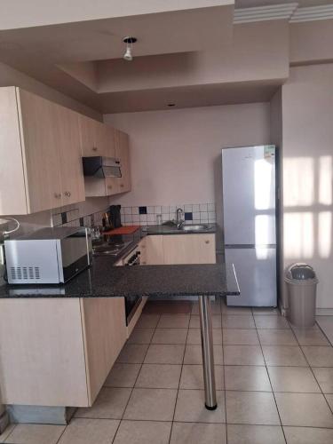 a kitchen with a refrigerator and a counter top at Mapungubwe hotel unit 525 in Johannesburg