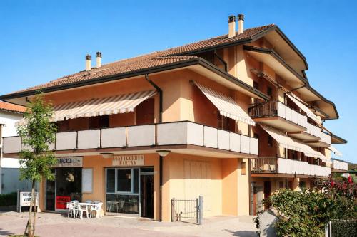 a large building with tables and chairs in front of it at Adria Residence in Gatteo a Mare