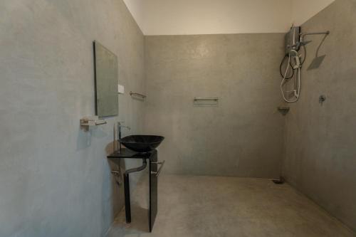 a bathroom with a sink and a mirror on the wall at Villa Pigeon Paradise in Unawatuna