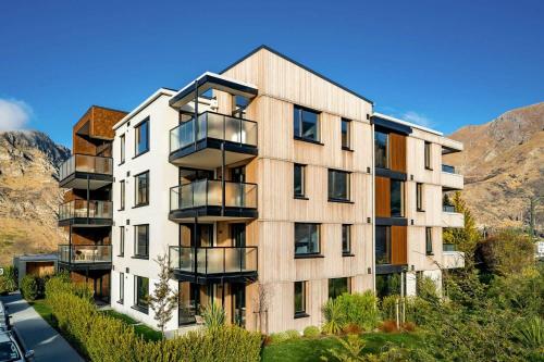 an apartment building with balconies on the side of a street at Hygge Garden Apartment in Queenstown