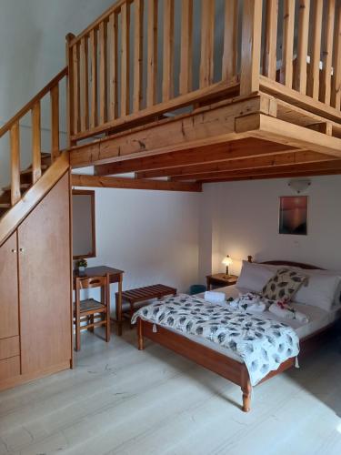 a bedroom with a bed and a wooden staircase at Ifestia Hotel in Kamari