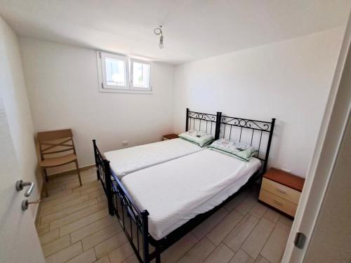 a bedroom with a bed and a chair in it at Serene Sea - Holiday Homes in Marina di Pescoluse