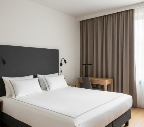 a bedroom with a large white bed and a desk at anka ra 06 in Dikmen