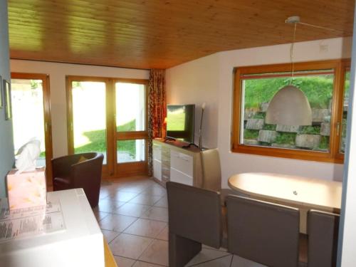 a kitchen with a table and chairs and a television at Apartment Weisshorn in Riederalp