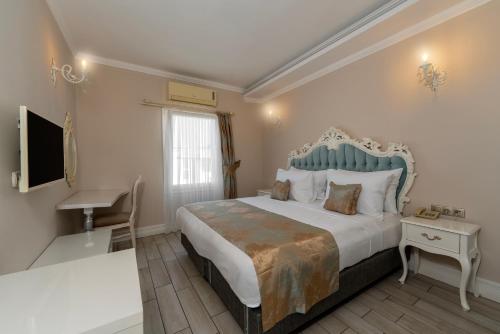 a bedroom with a large bed and a desk at Porto Azul Hotel Bodrum in Bodrum City