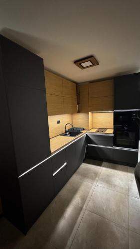 a kitchen with black cabinets and a sink at Luxury Apartments TRED in Pleven