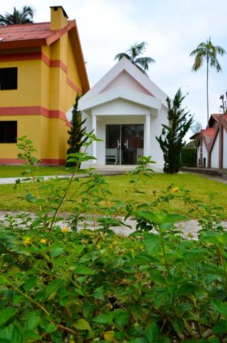 a house with a yellow and white at Hotel Girassol in Penedo