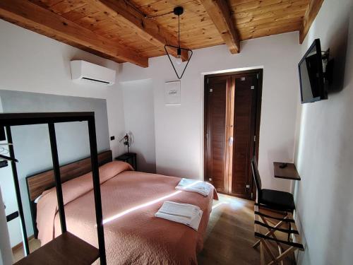 a bedroom with a bed and a television and a chair at Al Castello in Morano Calabro