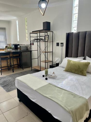 a bedroom with a large bed and a kitchen at Angel's Cottage Unit 1 in Paarl