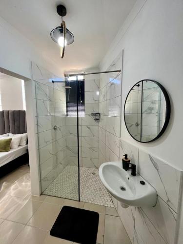 a bathroom with a shower and a sink and a mirror at Angel's Cottage Unit 1 in Paarl
