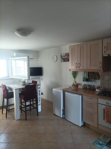 a kitchen with a table and a table and chairs at CASINA SULLa SABBIA in Torvaianica