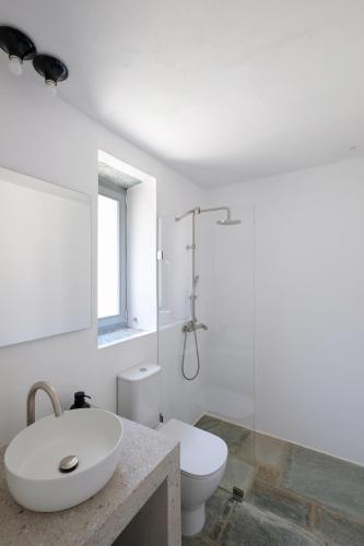 a white bathroom with a sink and a toilet at Kymo Kea in Otziás