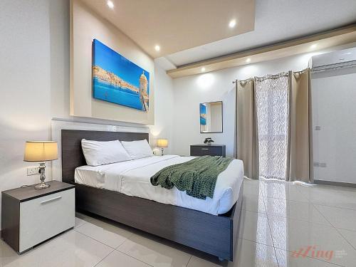 a bedroom with a large bed and a window at Elegant Seafront Duplex with Stunning Panoramic Views in Birżebbuġa