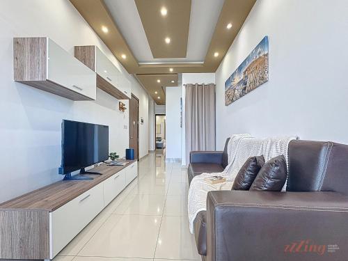 a living room with a tv and a couch at Elegant Seafront Duplex with Stunning Panoramic Views in Birżebbuġa