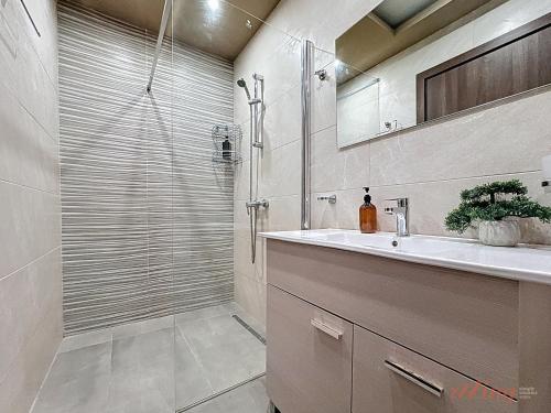 a bathroom with a sink and a shower at Elegant Seafront Duplex with Stunning Panoramic Views in Birżebbuġa