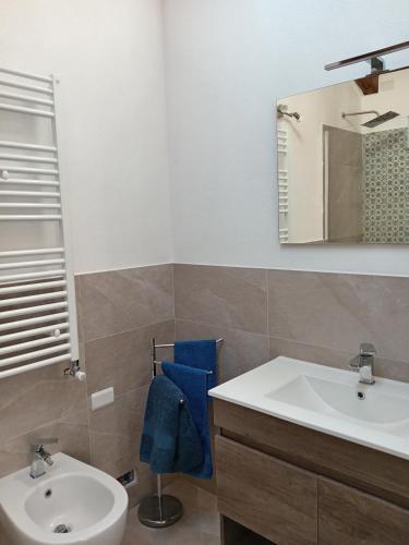 a bathroom with a sink and a toilet and a mirror at Vento di Mare - Tramontana con piscina in Moneglia