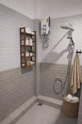 a bathroom with a shower with gray tiles at Villa Lilly in Rawai Beach