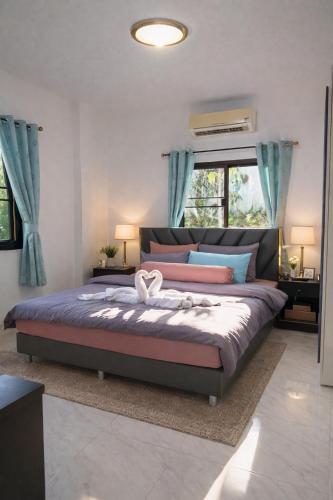 a bedroom with a large bed with blue curtains at Villa Lilly in Rawai Beach