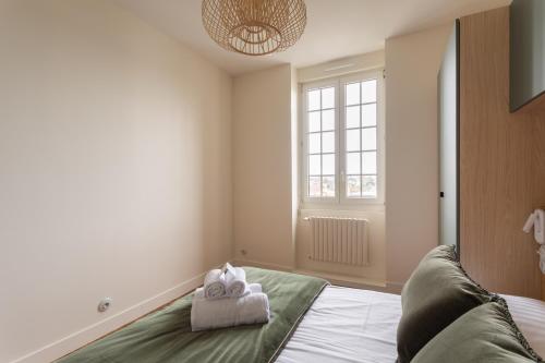a bedroom with a bed with towels on it at Ker Marlyne - Proche du Port in Dinard