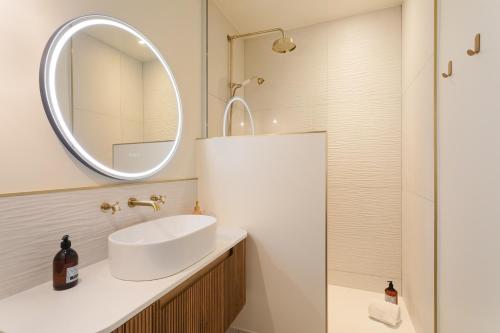 a bathroom with a sink and a mirror at Ker Marlyne - Proche du Port in Dinard