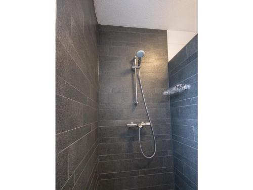 a bathroom with a shower with blue tiles at Christoffellaan 72 in Brouwershaven