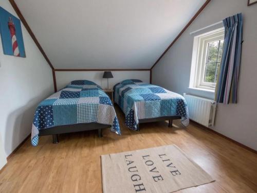 a bedroom with two beds and a rug on the floor at Christoffellaan 72 in Brouwershaven