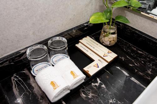 a table with three glass jars on a counter with a plant at V V Hotel Battambang in Battambang