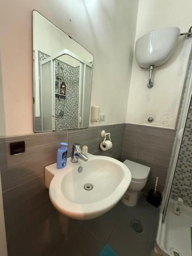 a bathroom with a sink and a toilet and a mirror at Da Alfred in Naples