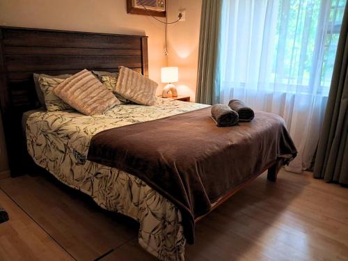 a bedroom with a bed with slippers on it at Just Property Zululand in Richards Bay