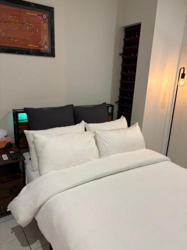 a white bed with white pillows in a room at Red Peak Retreat in Caravonica