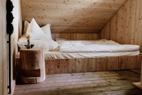 a bed in a wooden room with a table at Haslauer Hüttn in Frasdorf
