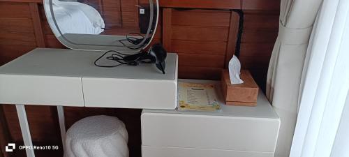 a white dresser with a mirror on top of it at The Indah Cliff Sea View in Polilit