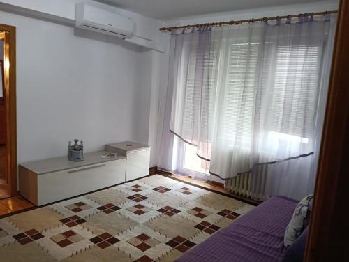 a bedroom with a bed and a window with curtains at ELENA Center Apartment in Timişoara