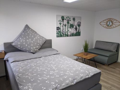 a bedroom with a bed and a chair at Bad Salzdetfurth Gästewohnungen in Bad Salzdetfurth